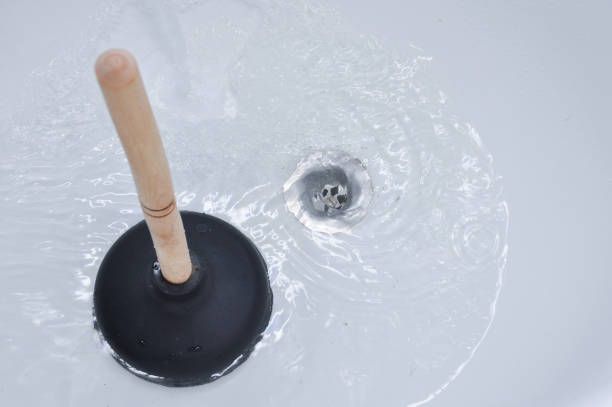 Plunger and clogged bath drain. Cleaning concept.